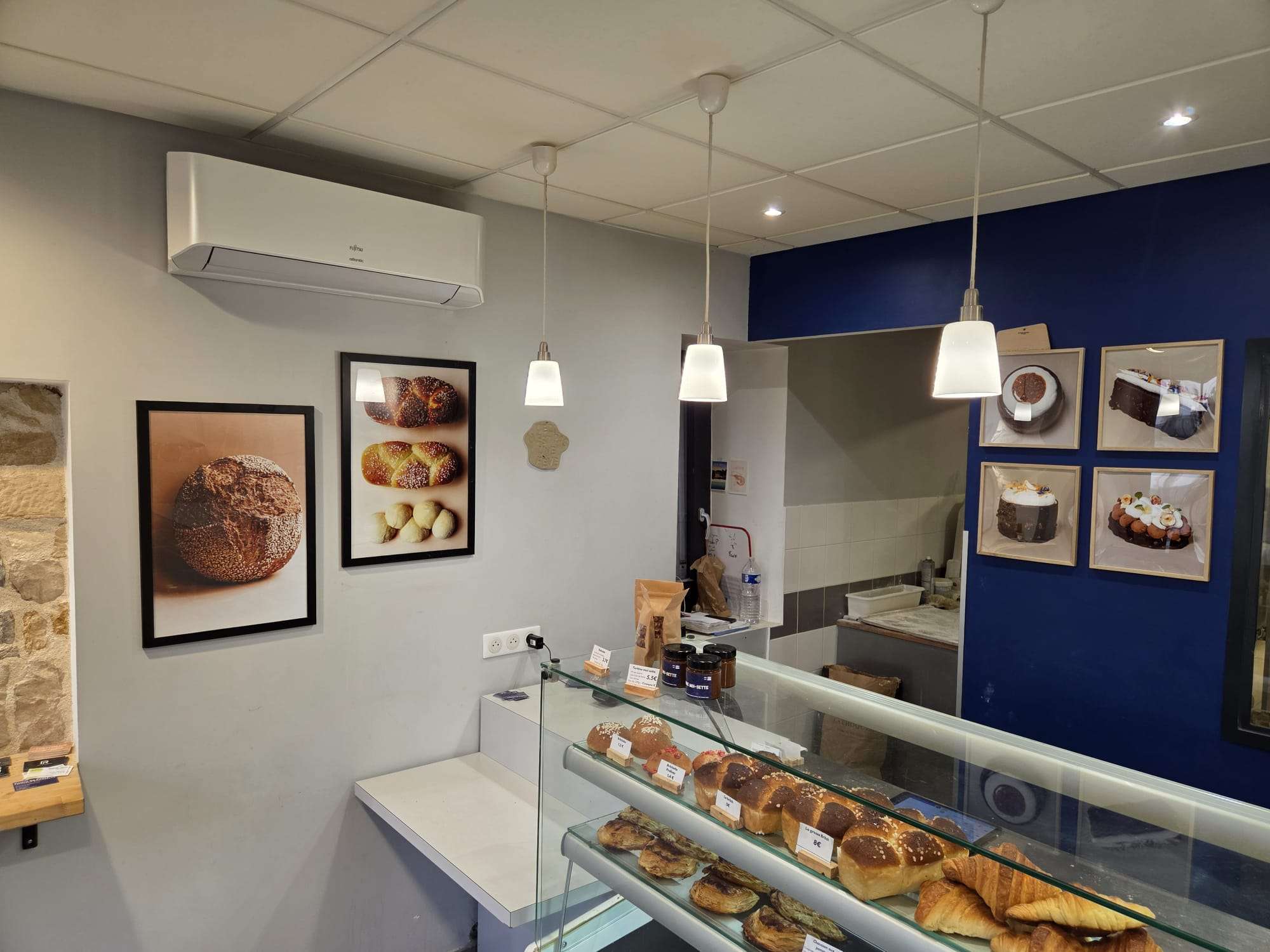 Intérieur de la boutique Pastry by Pauty : vitrine de brioches et viennoiseries, photos de créations au mur bleu